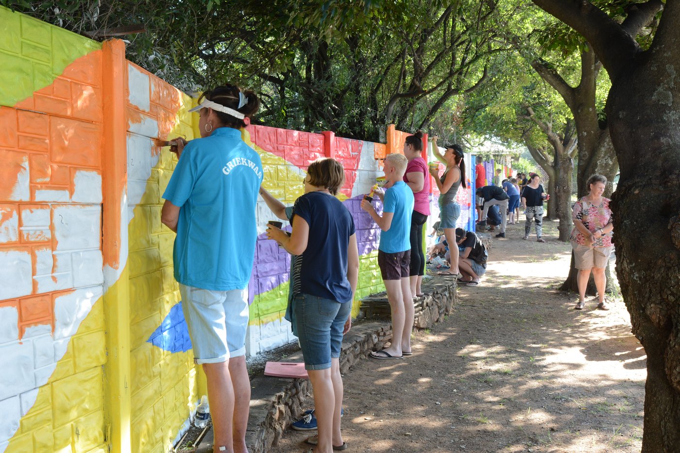 Community volunteers painting the geometric mural together